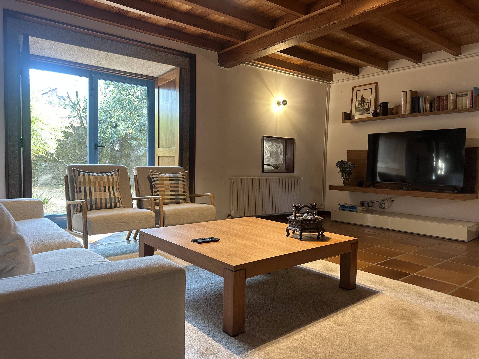 Salón de casa rural gallega con sofás y luz natural — Casa do Bidueiro