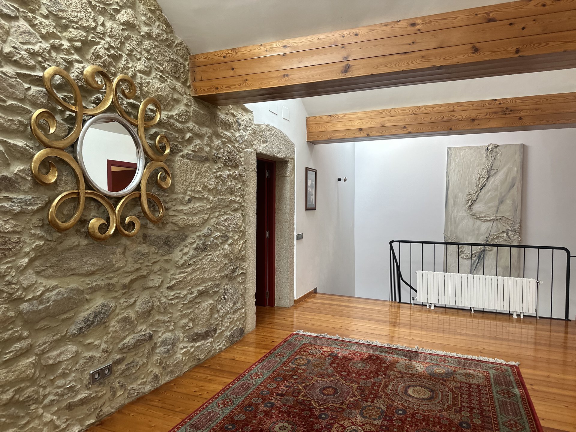 Salón de la primera planta con muro de piedra gallega — alojamiento rural Galicia